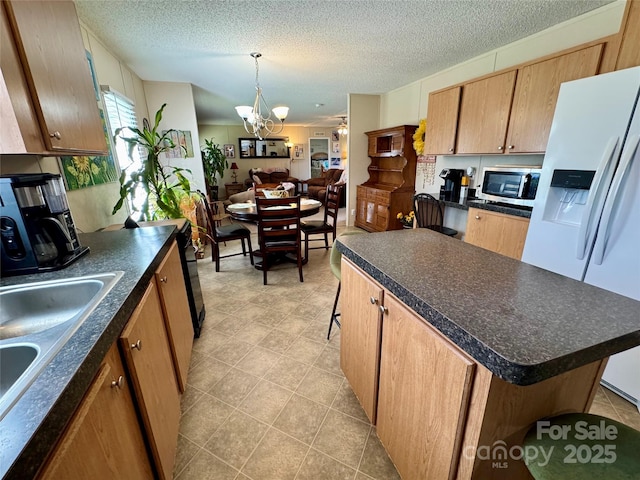 2084 Bristol Creek Ave, Morganton, NC 28655 - kitchen featuring stainless steel microwave, an inviting chandelier, dark countertops, and white refrigerator with ice dispenser