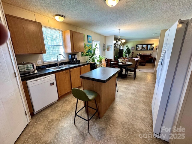 2084 Bristol Creek Ave, Morganton, NC 28655 - kitchen featuring dark countertops, a sink, white appliances, a center island, and a kitchen bar