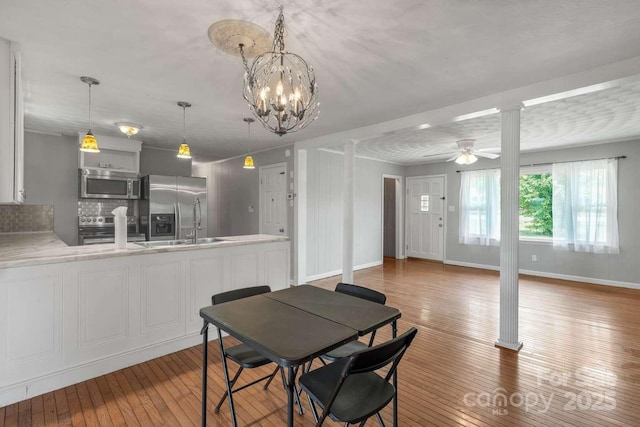 7527 Old Shelby Rd, Vale, NC 28168 - dining room with hardwood / wood-style flooring, a ceiling fan, a chandelier, baseboards, and ornate columns