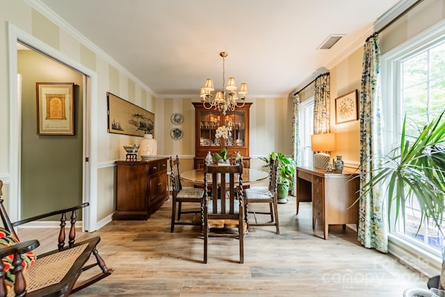 dining space with visible vents, a notable chandelier, light wood-style floors, and crown molding