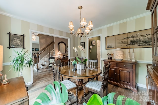 dining area featuring ornamental molding, stairway, wood finished floors, and a chandelier