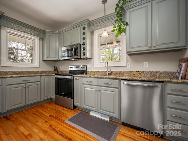 kitchen featuring gray cabinets, plenty of natural light, and stainless steel appliances