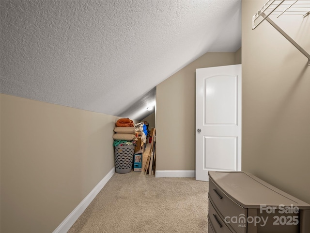 bonus room featuring light carpet, a textured ceiling, baseboards, and lofted ceiling