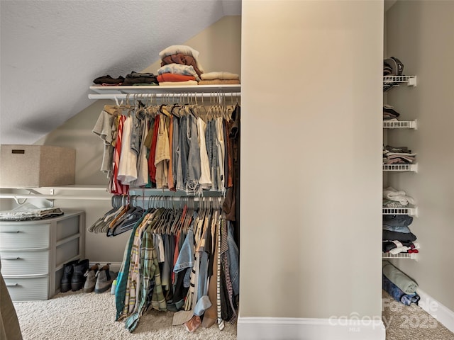 spacious closet featuring vaulted ceiling and carpet floors