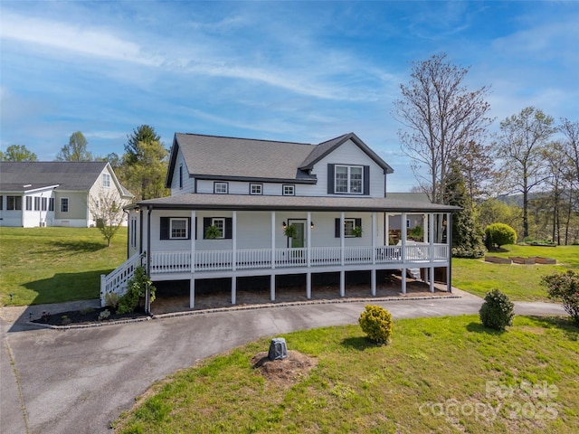 farmhouse inspired home featuring a porch, a shingled roof, and a front yard