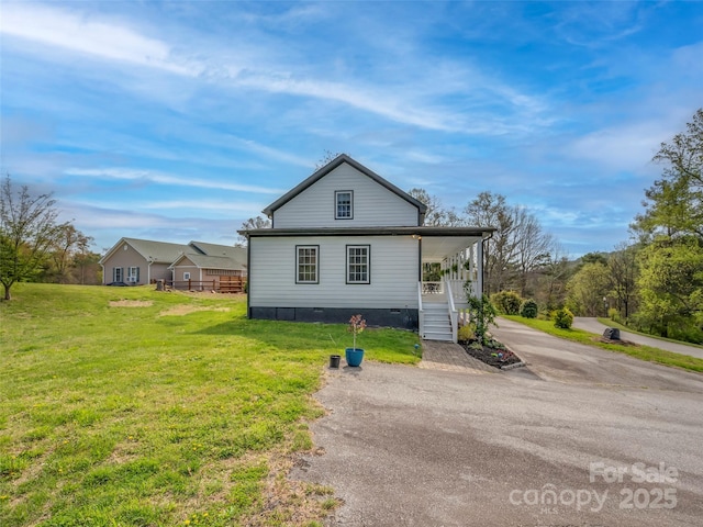 view of home's exterior featuring crawl space, a lawn, and covered porch