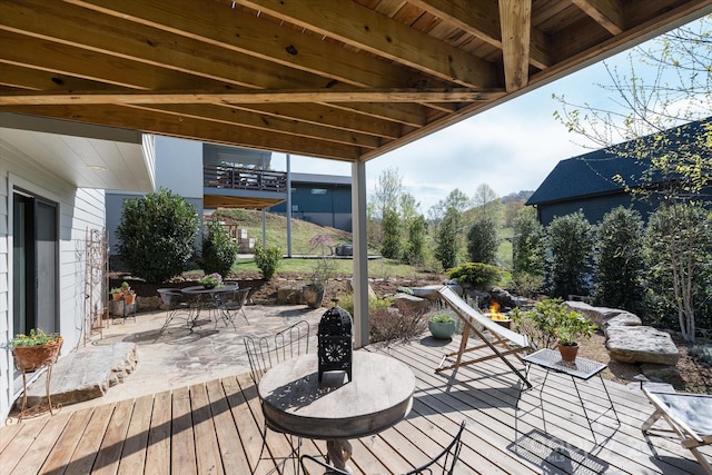 wooden terrace featuring outdoor dining space and a patio