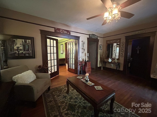 living room featuring french doors, baseboards, a ceiling fan, and wood finished floors
