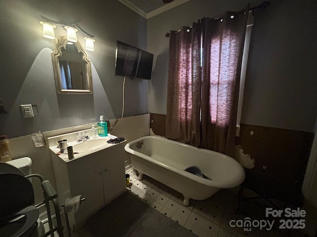 bathroom featuring a freestanding bath, tile patterned floors, vanity, and ornamental molding