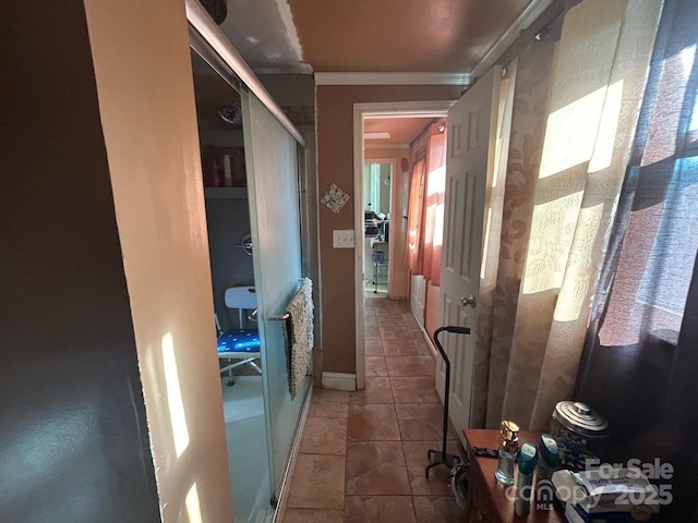 hallway featuring ornamental molding and tile patterned flooring