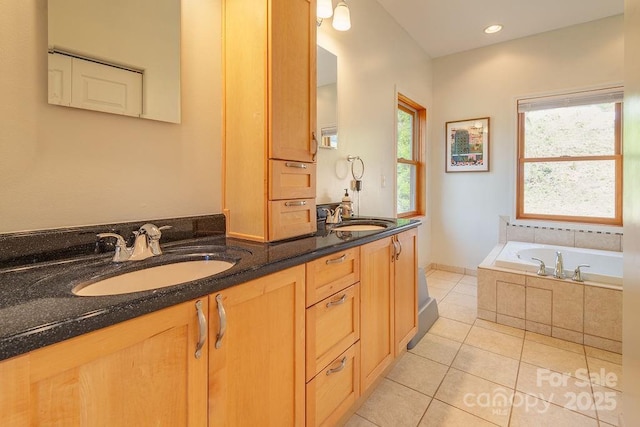 full bath with tiled tub, tile patterned floors, a sink, and double vanity