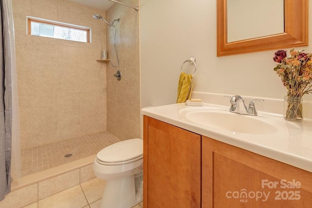 full bath featuring toilet, vanity, tile patterned floors, and tiled shower