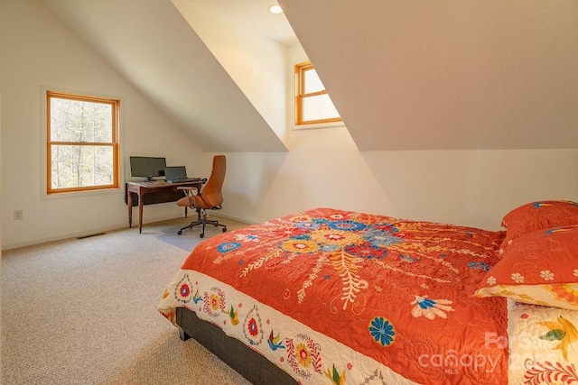 carpeted bedroom featuring lofted ceiling, multiple windows, visible vents, and baseboards