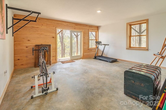exercise room with wooden walls and baseboards