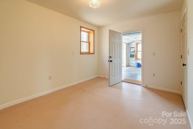 empty room with baseboards and finished concrete floors