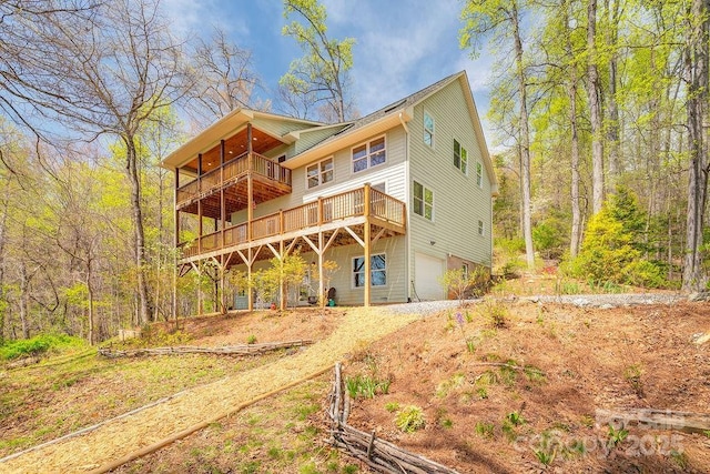 back of house with a wooden deck and a garage