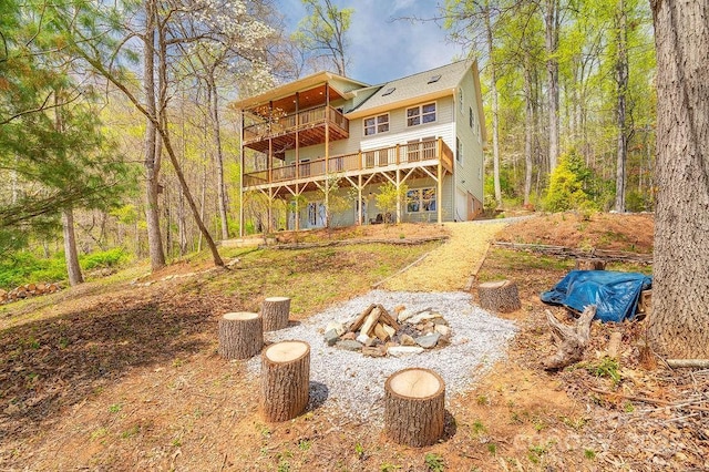 rear view of house featuring a fire pit and a wooden deck