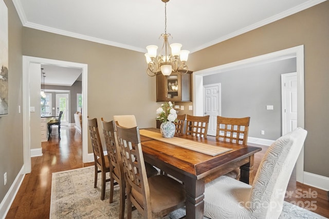 2501 Mt Isle Harbor Dr, Charlotte, NC 28214 - dining area featuring wood finished floors, crown molding, and an inviting chandelier