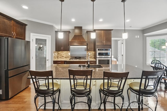 2501 Mt Isle Harbor Dr, Charlotte, NC 28214 - kitchen featuring stainless steel appliances, a sink, custom exhaust hood, decorative backsplash, and an island with sink