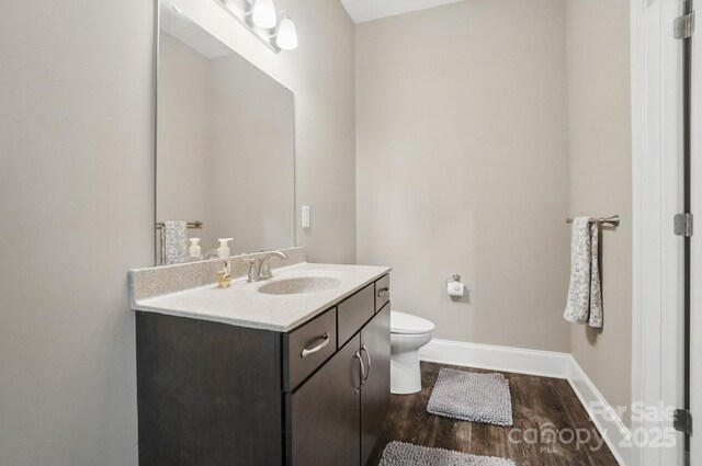 2501 Mt Isle Harbor Dr, Charlotte, NC 28214 - bathroom featuring baseboards, toilet, vanity, and wood finished floors