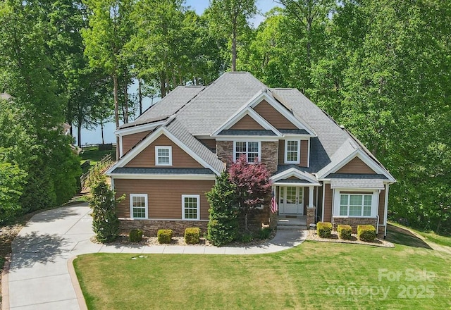 2501 Mt Isle Harbor Dr, Charlotte, NC 28214 - craftsman house featuring driveway, stone siding, a front yard, and a shingled roof