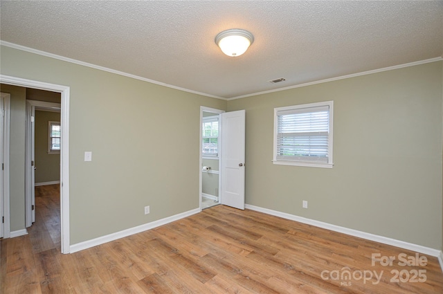 1222 Glenarden Dr, Rock Hill, SC 29730 - unfurnished room featuring a textured ceiling, visible vents, crown molding, baseboards, and light wood-style flooring