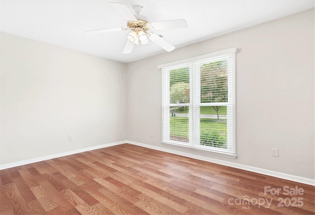empty room with baseboards, a ceiling fan, and wood finished floors
