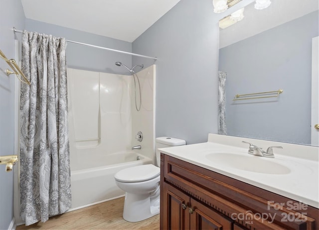 bathroom featuring toilet, wood finished floors, shower / tub combo with curtain, and vanity