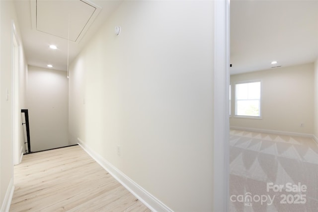 hallway with attic access, light wood-style floors, baseboards, and recessed lighting
