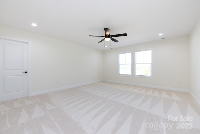 empty room featuring light colored carpet, baseboards, a ceiling fan, and recessed lighting