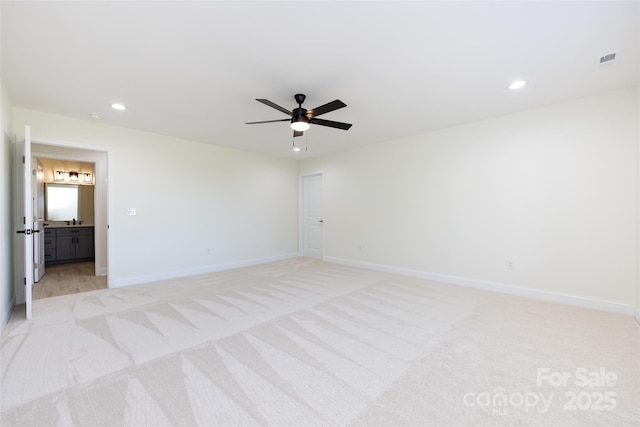 unfurnished bedroom featuring light carpet, baseboards, and recessed lighting