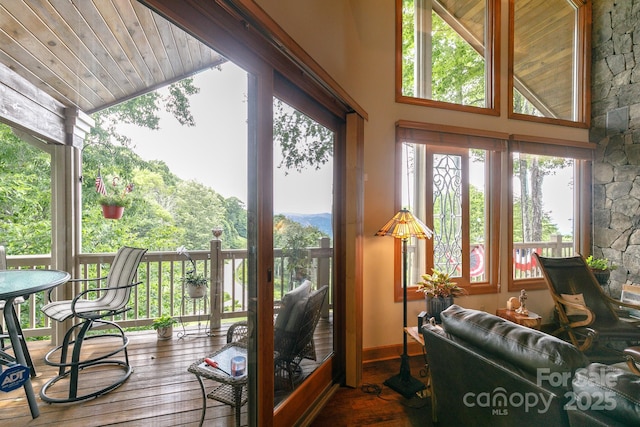 sunroom / solarium with wood-type flooring, baseboards, wooden ceiling, and vaulted ceiling