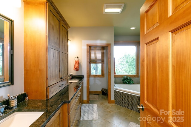 full bath featuring a garden tub, tile patterned floors, vanity, baseboards, and recessed lighting