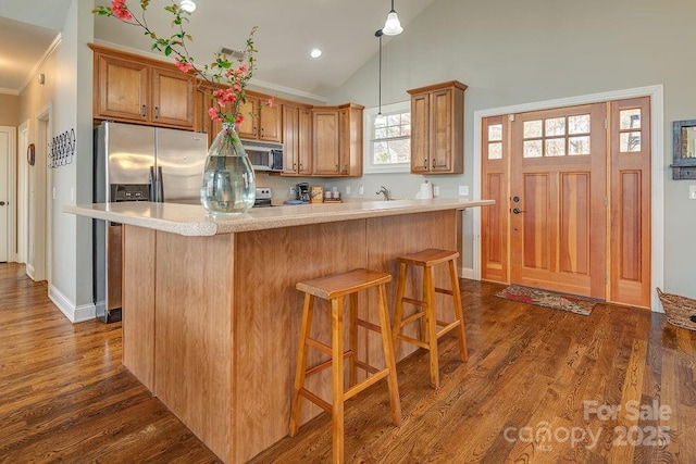 61 Buckle Rdg, Weaverville, NC 28787 - kitchen featuring stainless steel appliances, light countertops, dark wood-style floors, pendant lighting, and brown cabinets