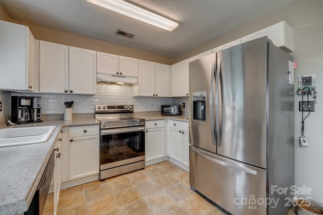 kitchen with a sink, white cabinetry, light countertops, under cabinet range hood, and appliances with stainless steel finishes