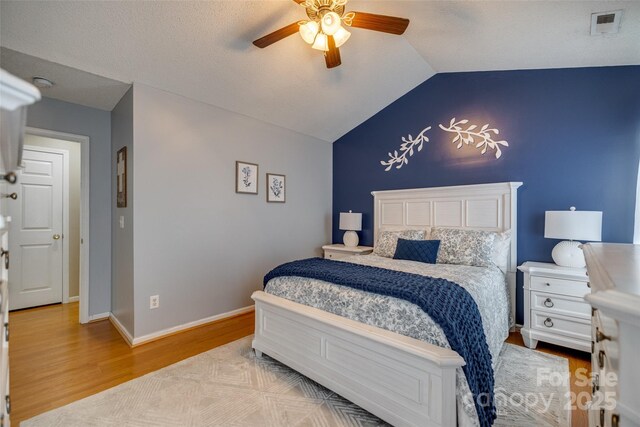 bedroom featuring ceiling fan, lofted ceiling, wood finished floors, and baseboards