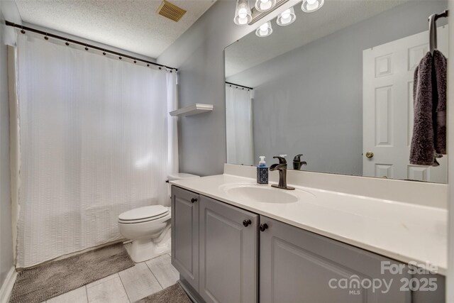 full bathroom featuring a textured ceiling, toilet, visible vents, shower / bath combo with shower curtain, and vanity