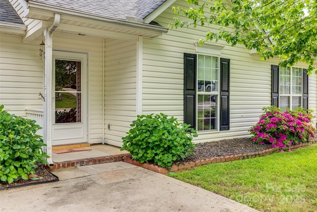 doorway to property with roof with shingles