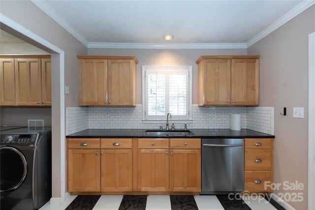 kitchen featuring washer / dryer, a sink, stainless steel dishwasher, dark countertops, and crown molding