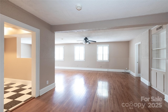spare room with ceiling fan, a textured ceiling, wood finished floors, a smoke detector, and baseboards