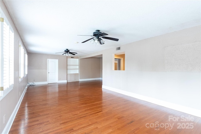 unfurnished room with light wood-type flooring, baseboards, and ceiling fan