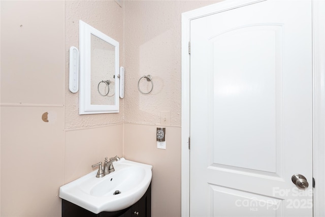 bathroom with vanity and a textured wall