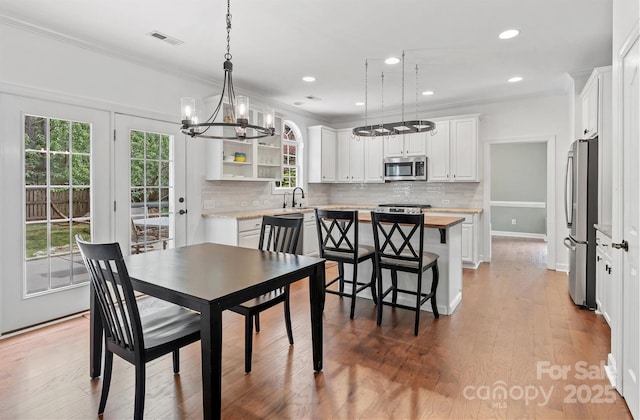 14220 Stewarts Bend Ln, Charlotte, NC 28277 - dining room featuring an inviting chandelier, ornamental molding, visible vents, and plenty of natural light