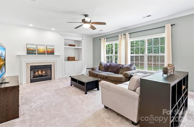 14220 Stewarts Bend Ln, Charlotte, NC 28277 - living area with visible vents, ornamental molding, built in features, a glass covered fireplace, and a ceiling fan