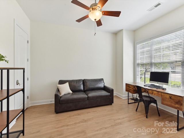 office space with baseboards, light wood finished floors, ceiling fan, and a healthy amount of sunlight