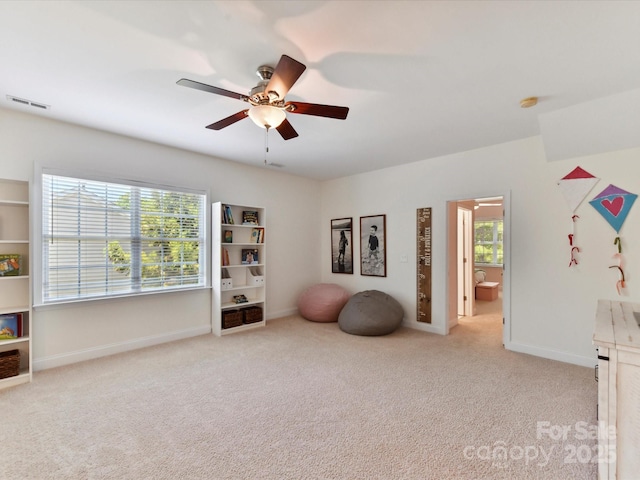 interior space with baseboards, a ceiling fan, carpet flooring, and visible vents