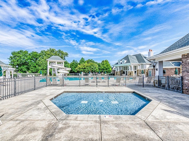 community pool with fence and a patio