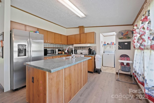 6282 Lor Rd, Morganton, NC 28655 - kitchen featuring a textured ceiling, a sink, washer / dryer, stainless steel appliances, and light wood finished floors