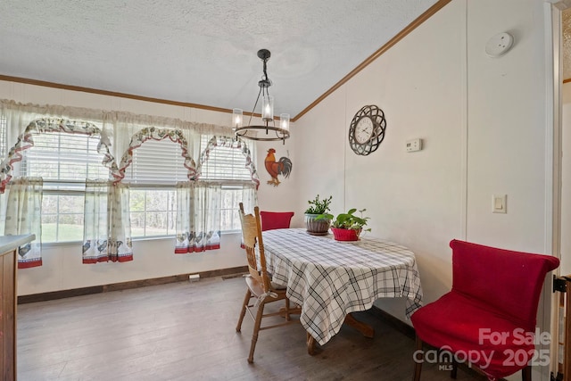 6282 Lor Rd, Morganton, NC 28655 - dining space with an inviting chandelier, vaulted ceiling, wood finished floors, ornamental molding, and a textured ceiling