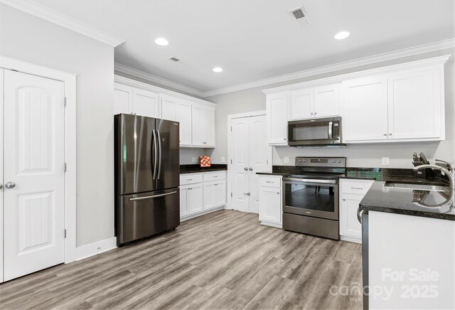 10340 Williams Rd, Mint Hill, NC 28227 - kitchen with appliances with stainless steel finishes, a sink, crown molding, white cabinetry, and light wood-style floors